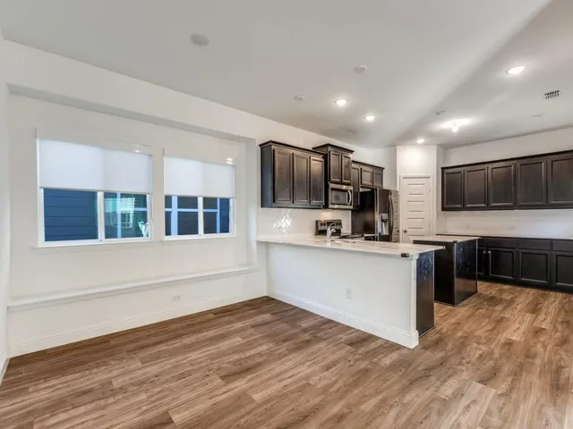 a kitchen with stainless steel appliances granite countertop a refrigerator and a stove top oven