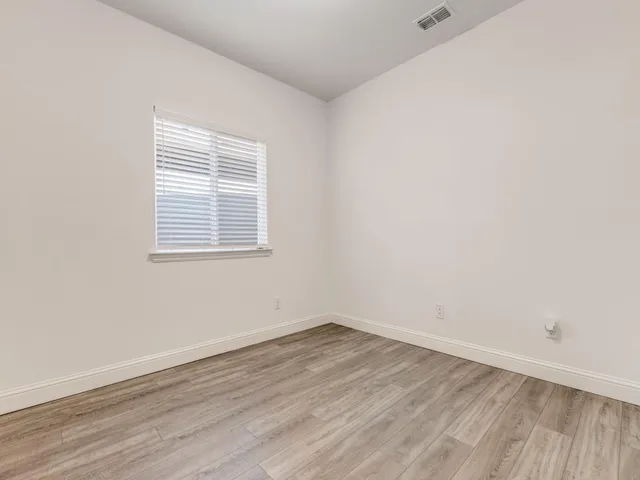 an empty room with wooden floor and a window