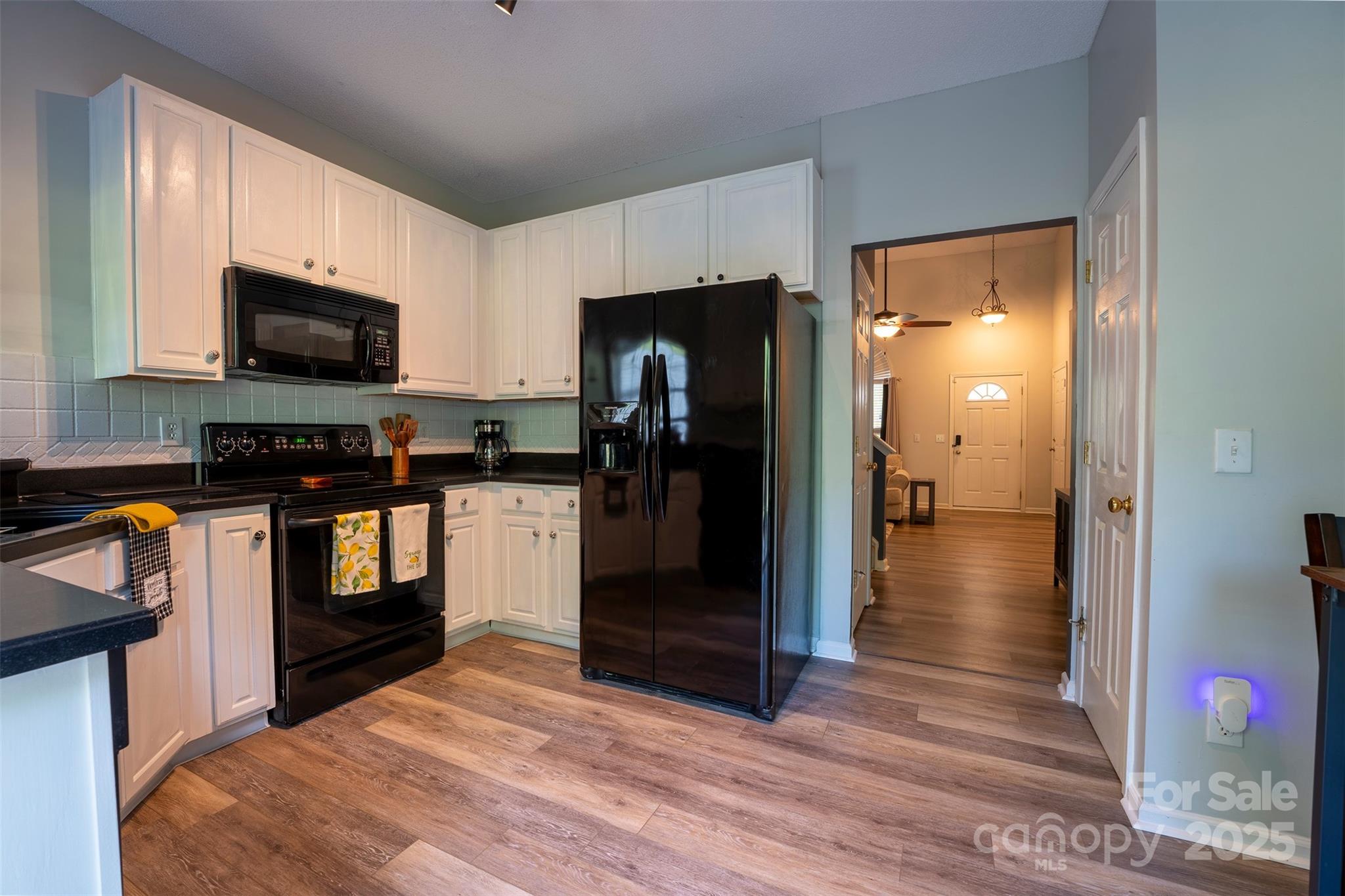 3412 Summerfield Ridge Lane Matthews, NC 28105 - Photo 7 of 30 a kitchen with granite countertop a refrigerator and a stove top oven