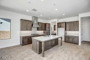 a large kitchen with stainless steel appliances granite countertop a stove refrigerator and a sink