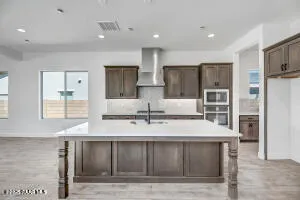 a view of kitchen with stainless steel appliances kitchen island granite countertop a refrigerator and cabinets