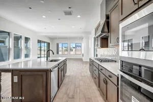 a kitchen with stainless steel appliances granite countertop lots of counter space and wooden floors
