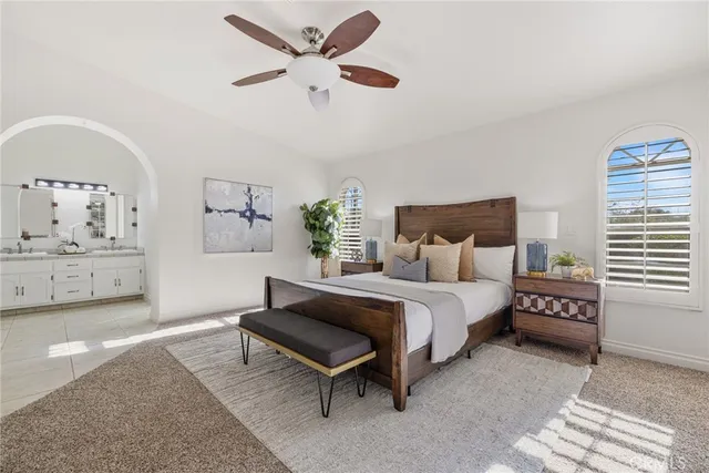 a spacious bedroom with a bed a window and a chandelier