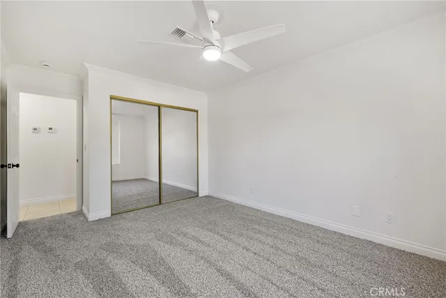 an empty room with a ceiling fan and a window