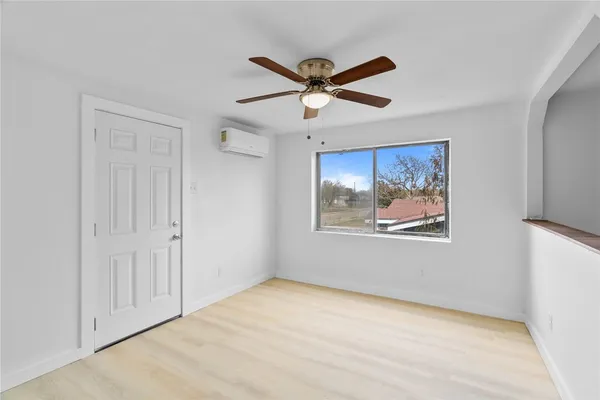 a view of a big room with wooden floor and windows