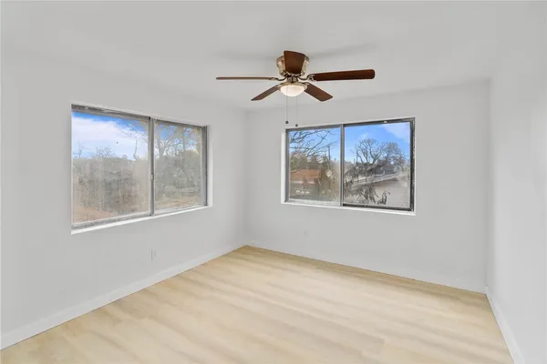a view of empty room with window and wooden floor