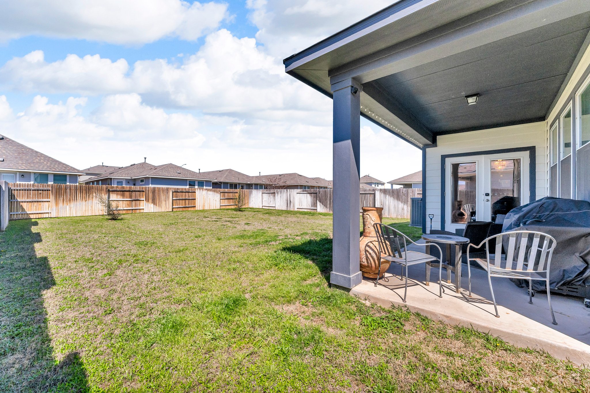 306 Cold Spg Loop Bastrop, TX 78602 - Photo 23 of 25 View of yard featuring french doors, a residential view, a fenced backyard, and a patio area