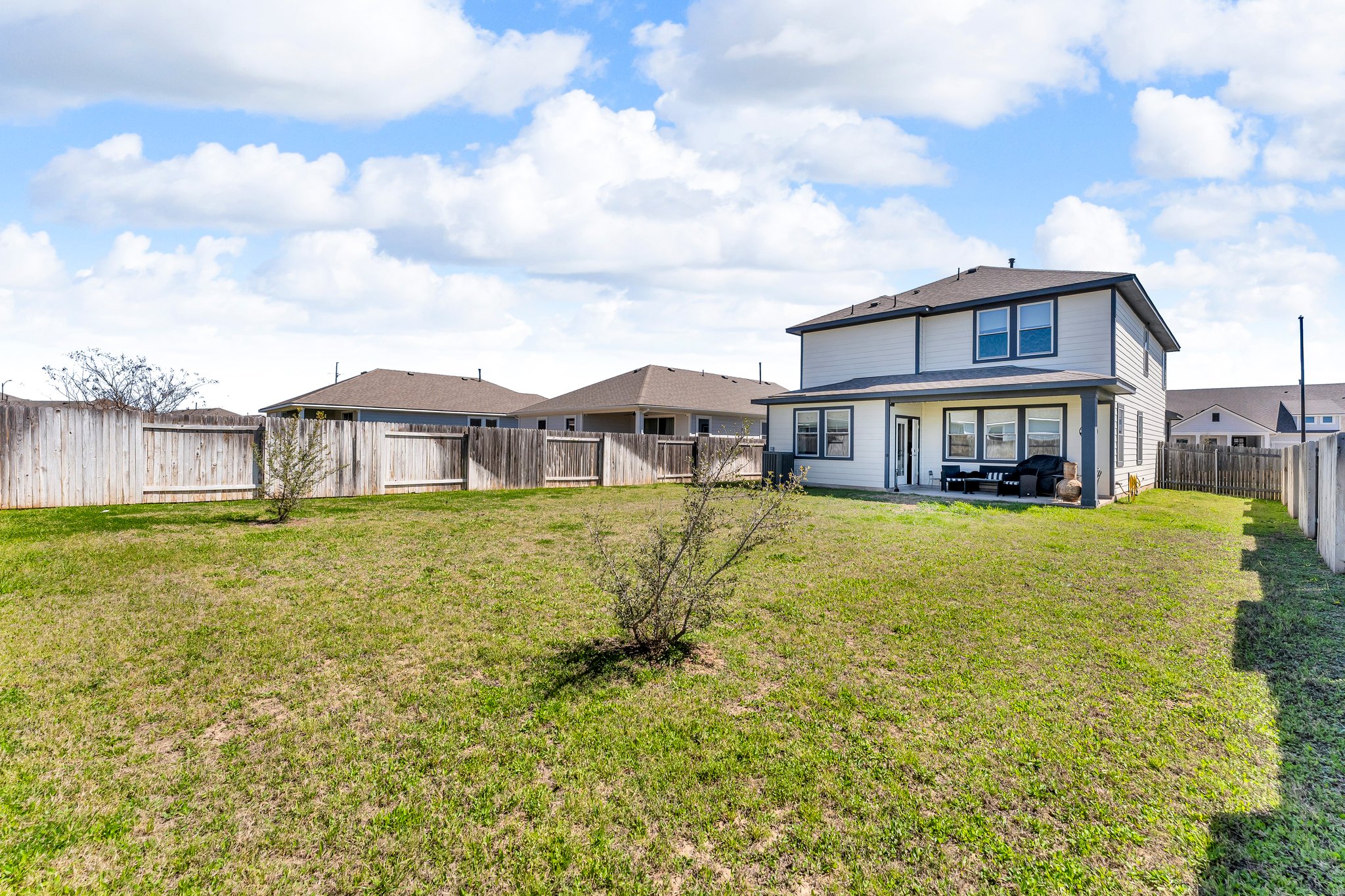 306 Cold Spg Loop Bastrop, TX 78602 - Photo 24 of 25 Rear view of house with a patio area, a yard, and a fenced backyard