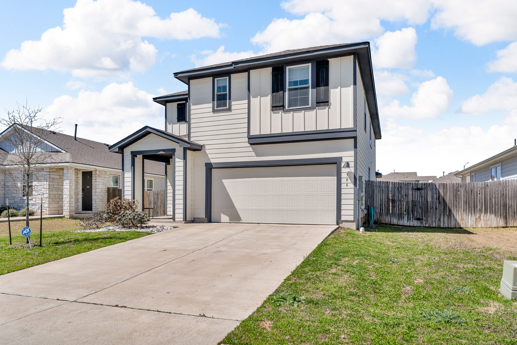 306 Cold Spg Loop Bastrop, TX 78602 - Photo 3 of 25 View of front facade featuring a front lawn, fence, board and batten siding, and driveway