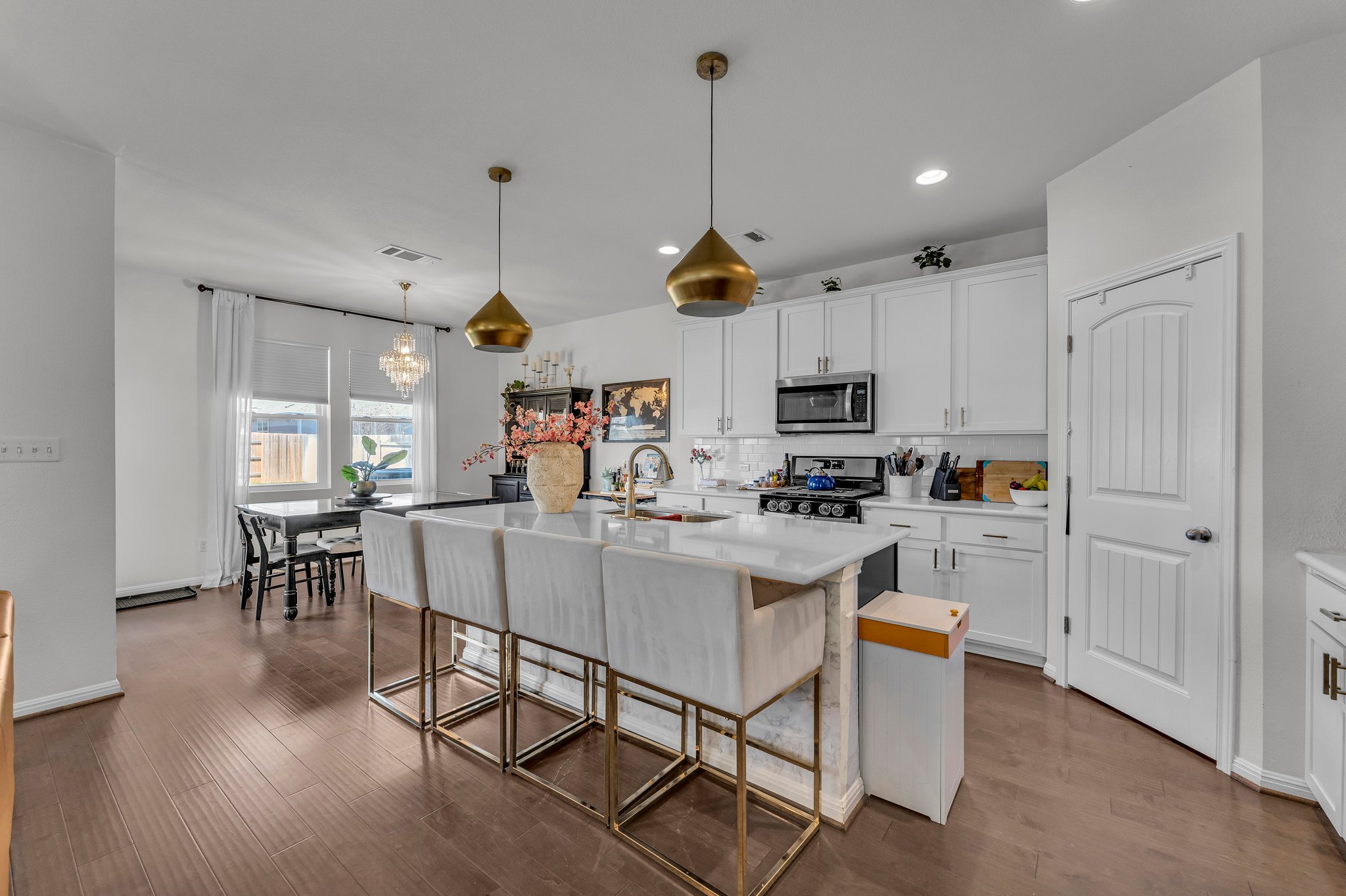 306 Cold Spg Loop Bastrop, TX 78602 - Photo 8 of 25 Kitchen with visible vents, a sink, stainless steel appliances, white cabinetry, and a kitchen breakfast bar