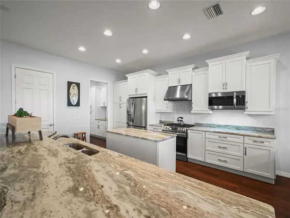 a kitchen with a sink stove and wooden floor