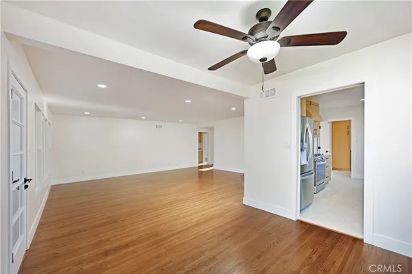 a view of an empty room with wooden floor