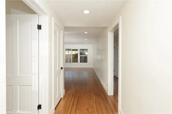 a view of a hallway with wooden floor