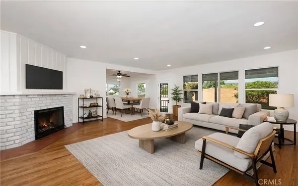 a living room with furniture fireplace and a large window