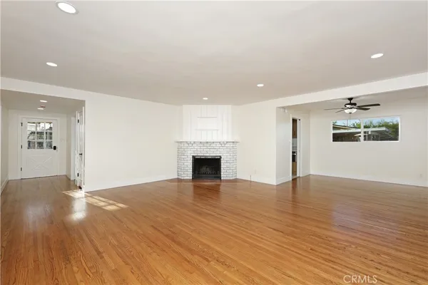 an empty room with wooden floor and fireplace