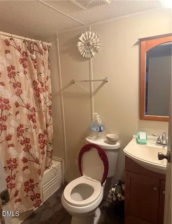 a bathroom with a granite countertop toilet sink and mirror