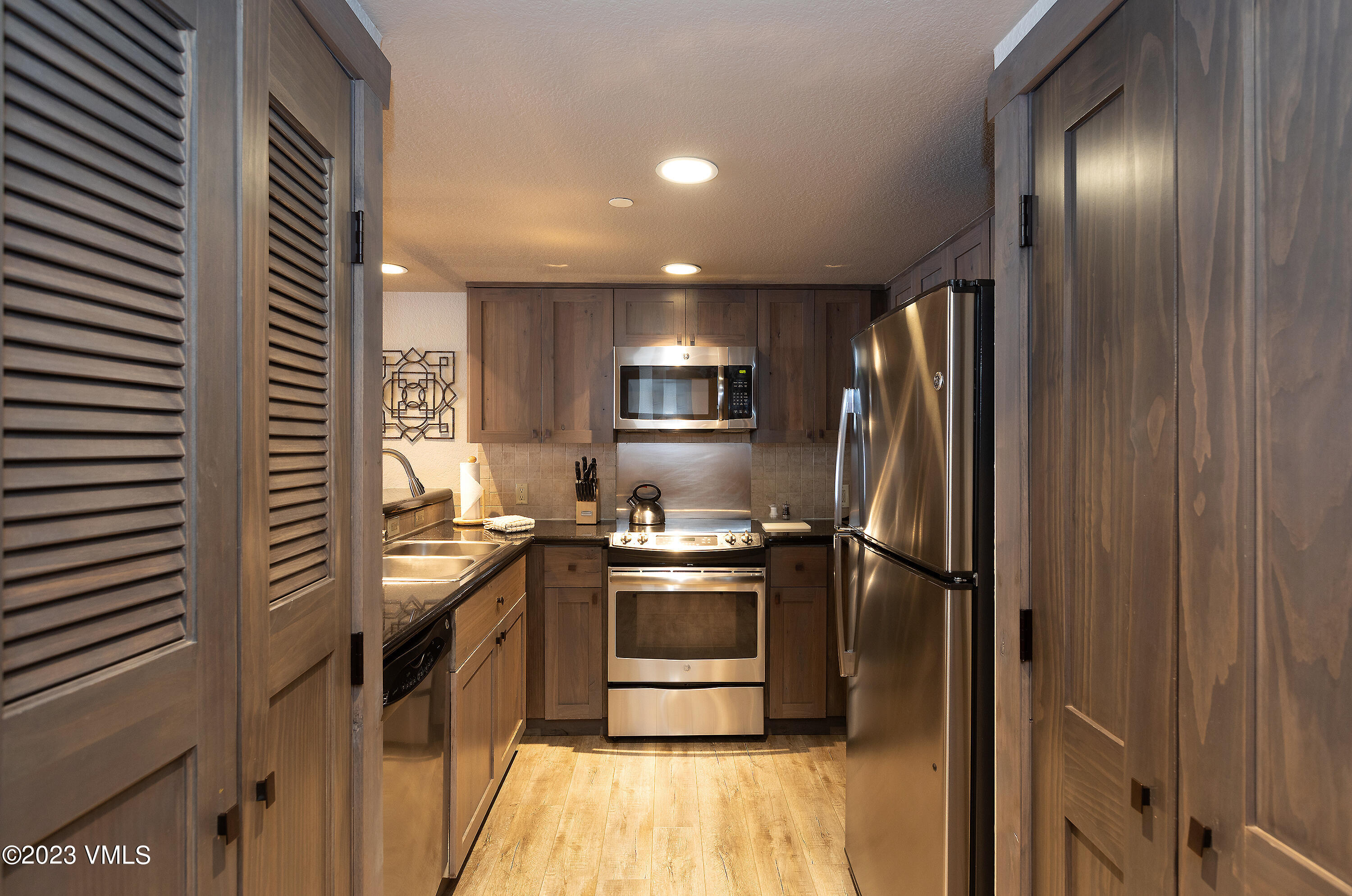 210 Offerson Road, Unit 107 WEEK 5 Beaver Creek, CO 81620 - Photo 8 of 27 a kitchen with stainless steel appliances granite countertop a refrigerator a sink and a stove