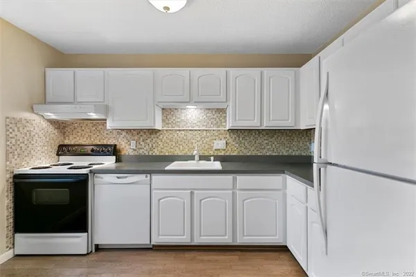 a kitchen with white cabinets and white appliances