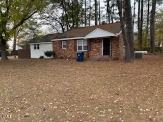 a view of a house with a yard and large tree