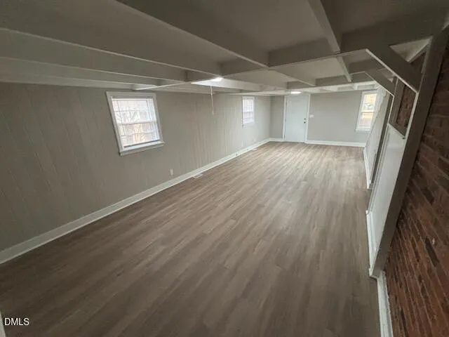 a view of empty room with wooden floor