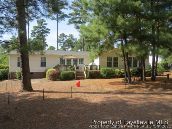 293 Ridge View Drive Cameron, NC 28326 - Photo 22 of 25 a view of a white house in front of a yard with plants and large trees