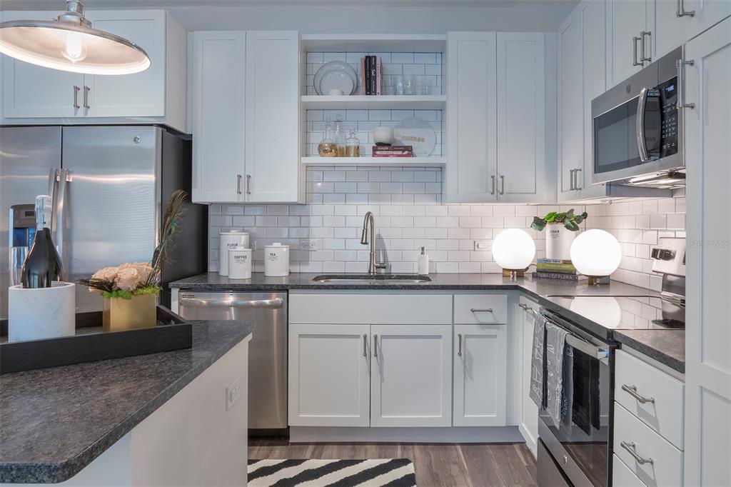 733 Main Lane, Unit 2 Orlando, FL 32801 - Photo 15 of 19 a kitchen with stainless steel appliances granite countertop a sink stove and cabinets