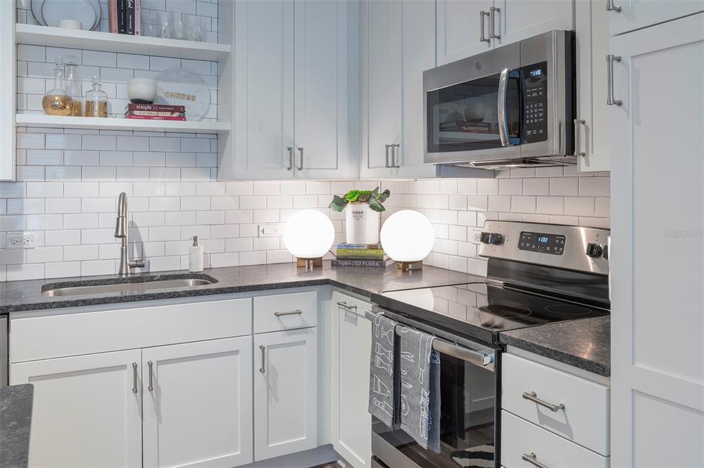 733 Main Lane, Unit 2 Orlando, FL 32801 - Photo 17 of 19 a kitchen with stainless steel appliances granite countertop a sink a stove and wooden cabinets