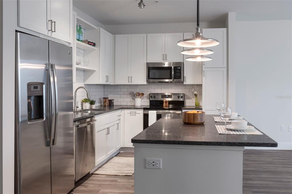 733 Main Lane, Unit 2 Orlando, FL 32801 - Photo 18 of 19 a kitchen with stainless steel appliances granite countertop a sink a stove and refrigerator