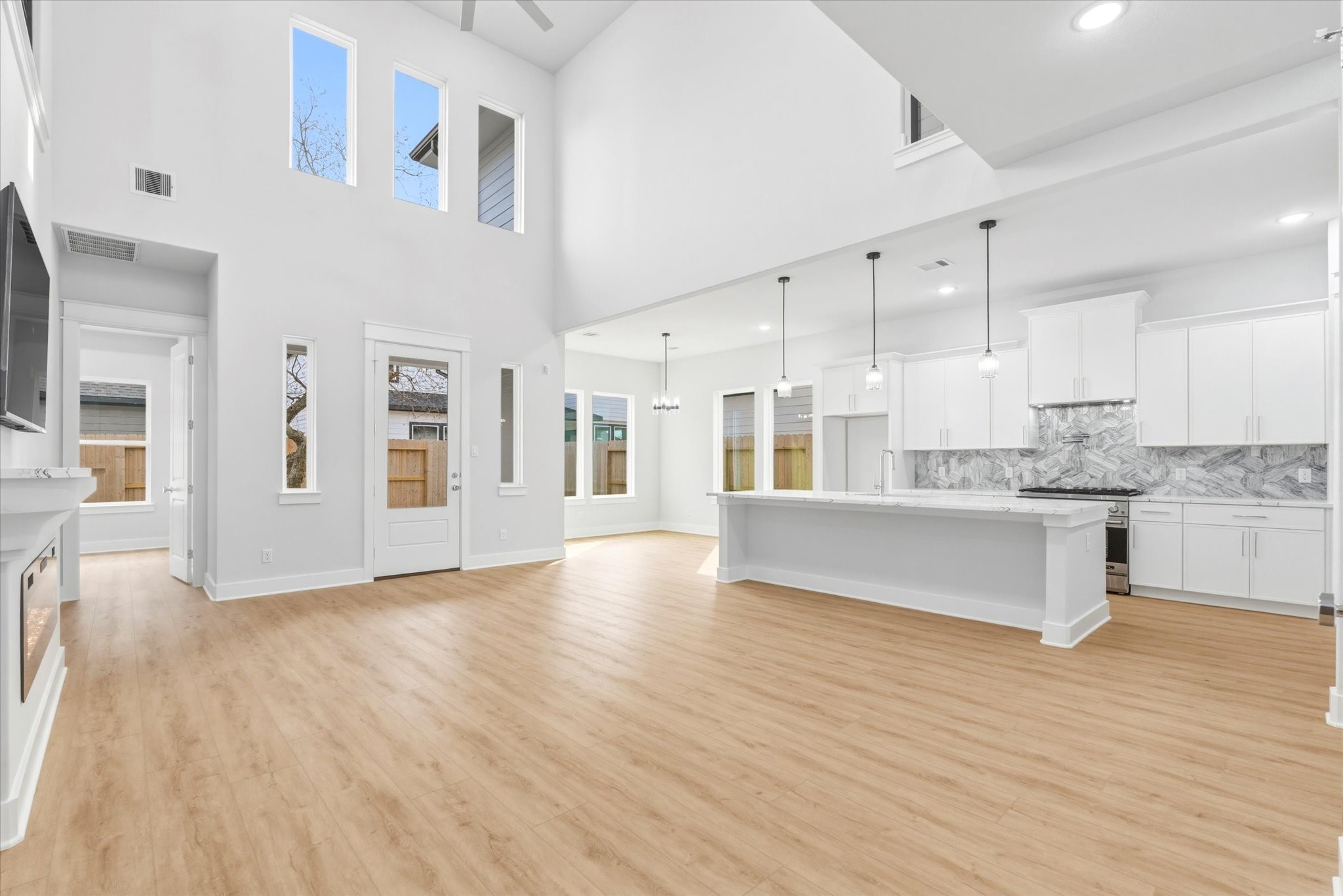11626 Flintlock Road La Porte, TX 77571 - Photo 3 of 26 a large white kitchen with granite countertop a stove top oven a sink and white cabinets with wooden floor