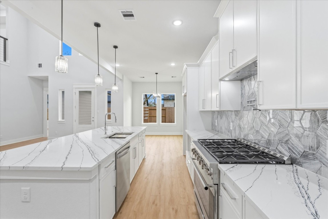 11626 Flintlock Road La Porte, TX 77571 - Photo 6 of 26 The spacious 10 foot island features an under-mount sink and built in dishwasher. Three pendant lights above add warmth and modern charm.