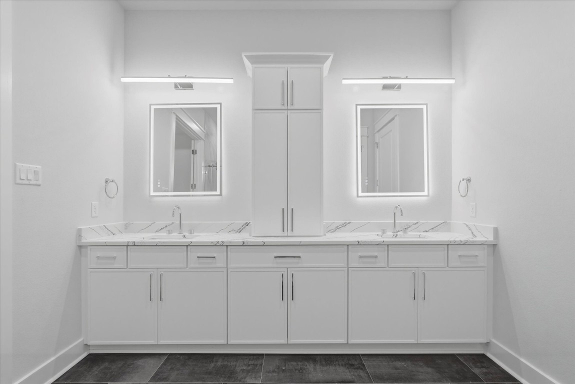 11626 Flintlock Road La Porte, TX 77571 - Photo 10 of 26 The primary bathroom features elegant quartz countertops and soft-close cabinet doors for quiet functionality, along with modern lighting and backlit mirrors that provide excellent illumination.