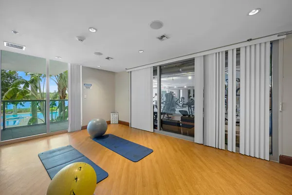 a bedroom with a bed and large windows