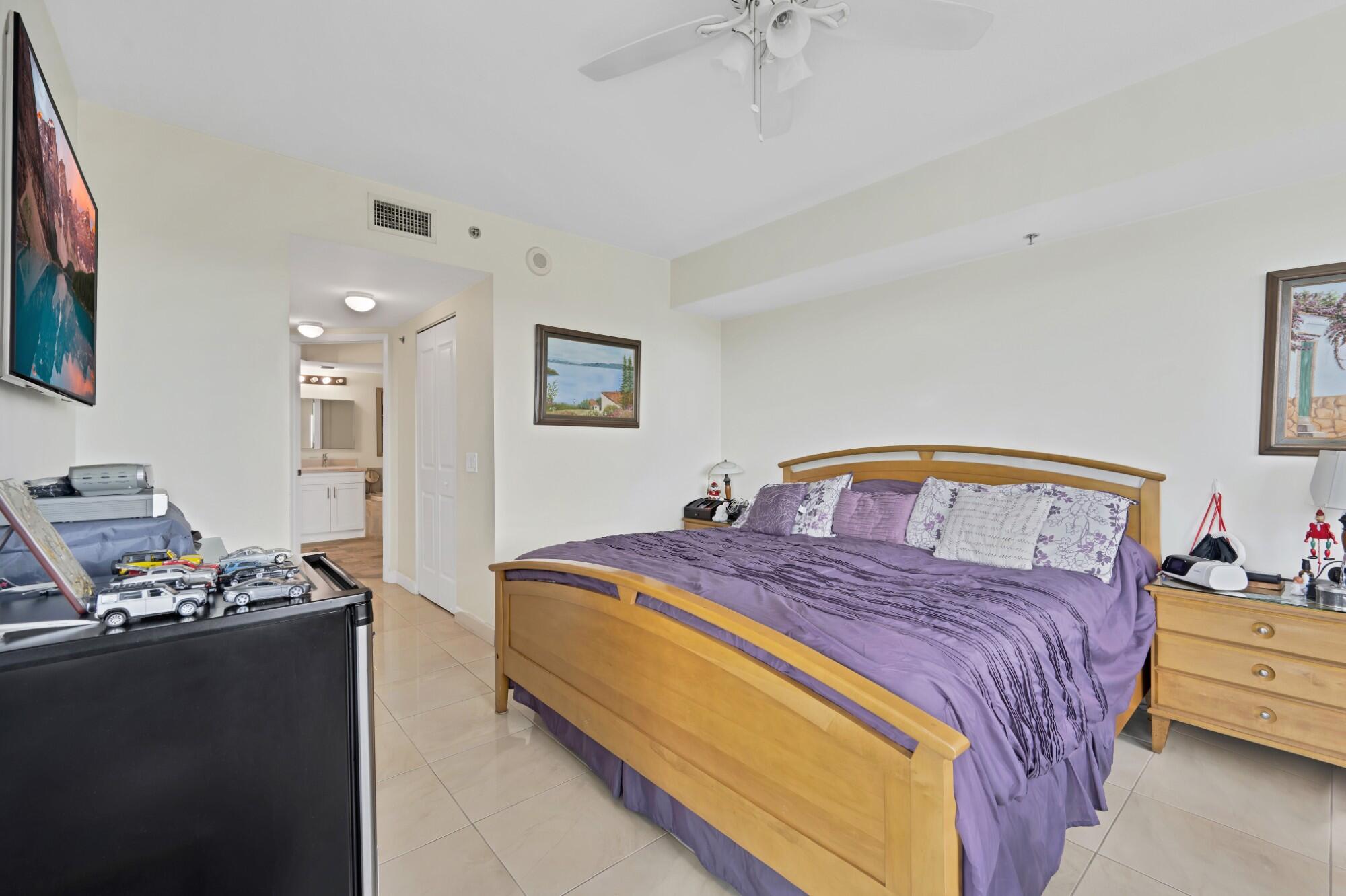 2641 North Flamingo Road, Unit 2108N Sunrise, FL 33323 - Photo 32 of 52 a bedroom with a bed and a night stand