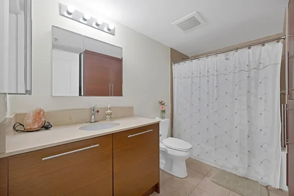 a bathroom with a granite countertop sink a toilet and mirror
