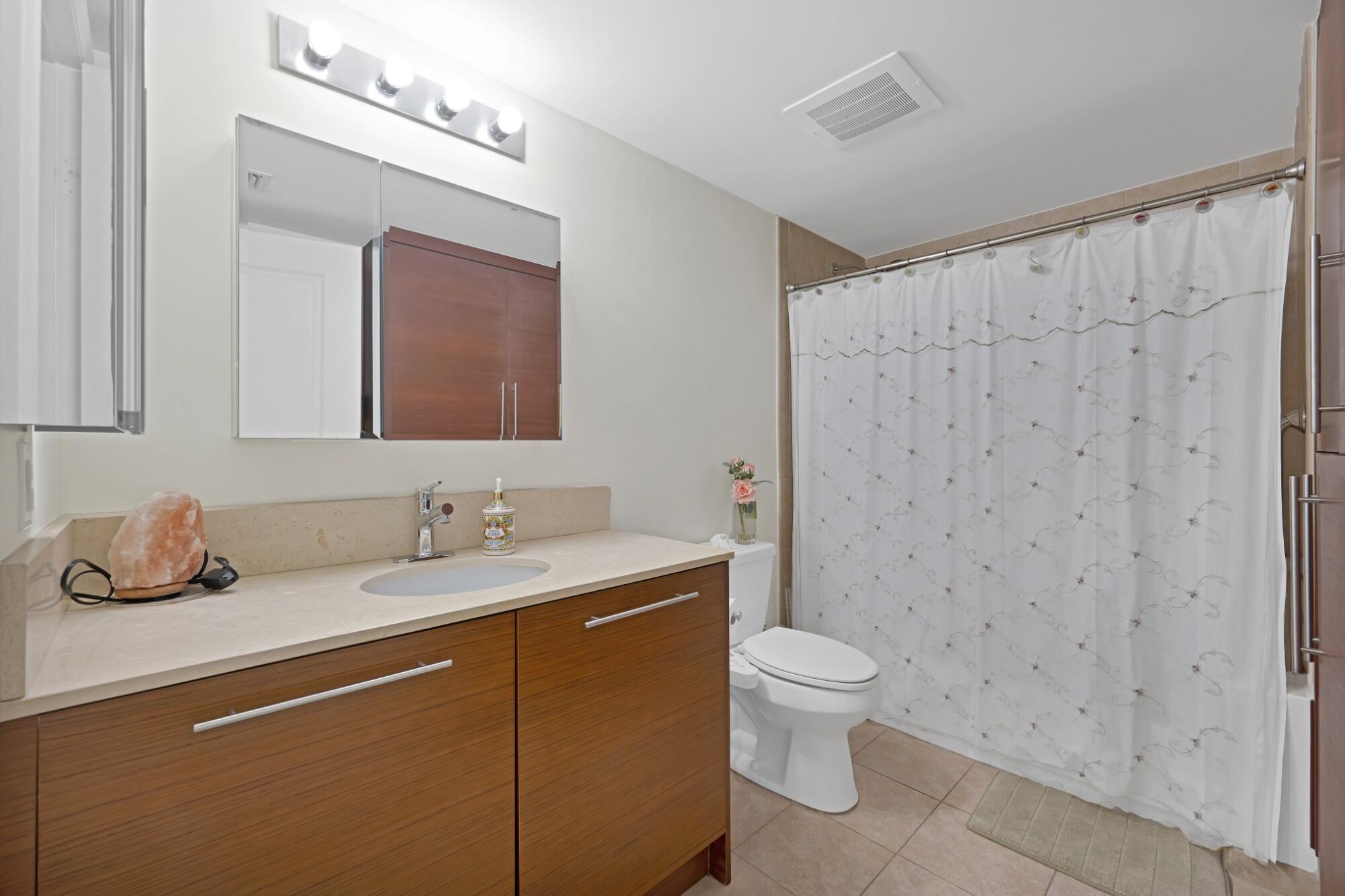 2641 North Flamingo Road, Unit 2108N Sunrise, FL 33323 - Photo 37 of 52 a bathroom with a granite countertop sink a toilet and a mirror