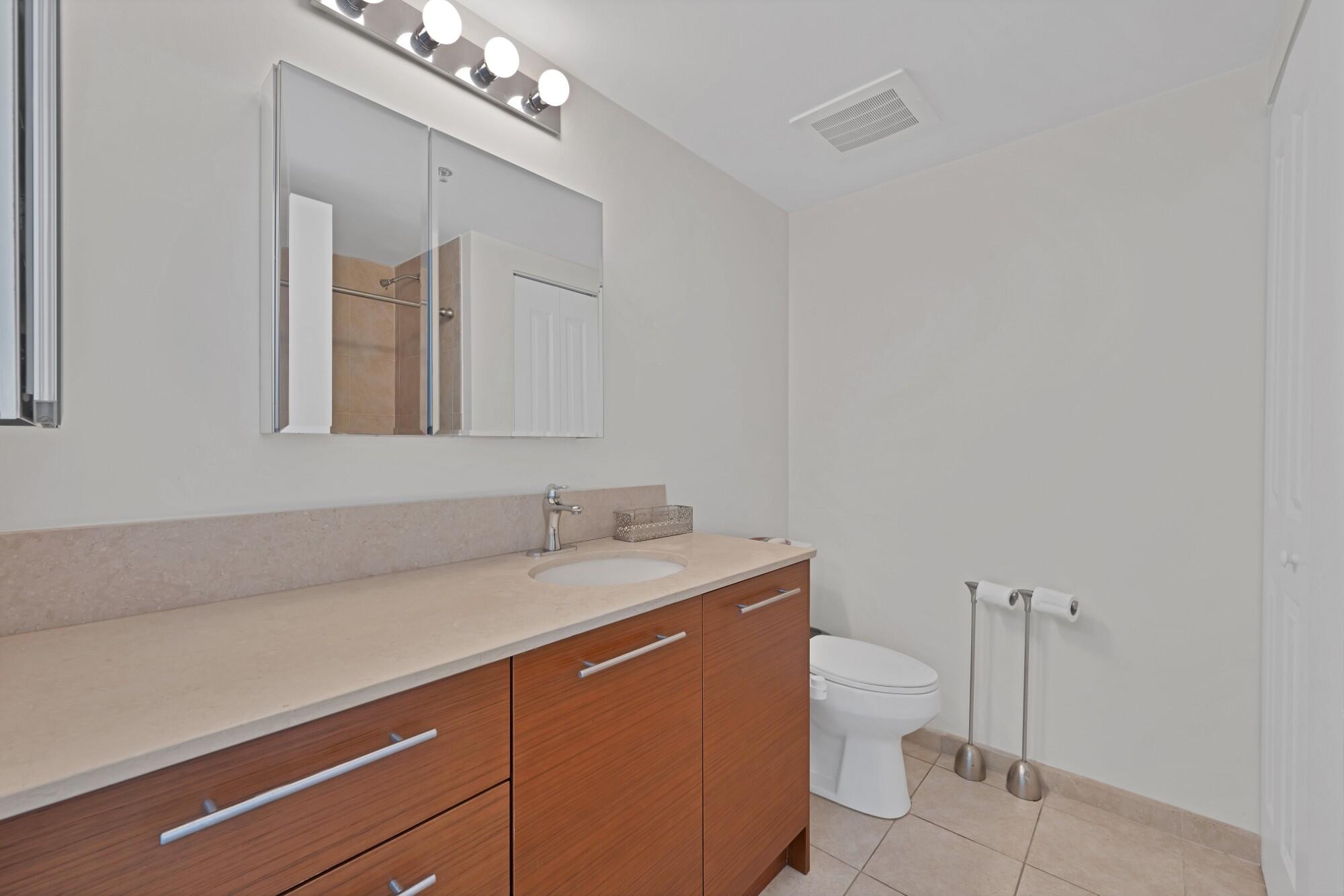 2641 North Flamingo Road, Unit 2108N Sunrise, FL 33323 - Photo 38 of 52 a bathroom with a granite countertop sink a toilet and mirror