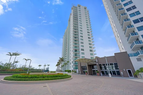a front view of a multi story residential apartment building with a yard
