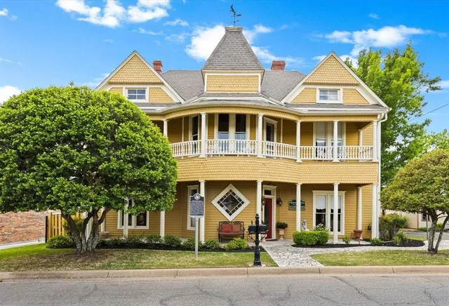 front view of a brick house with a yard