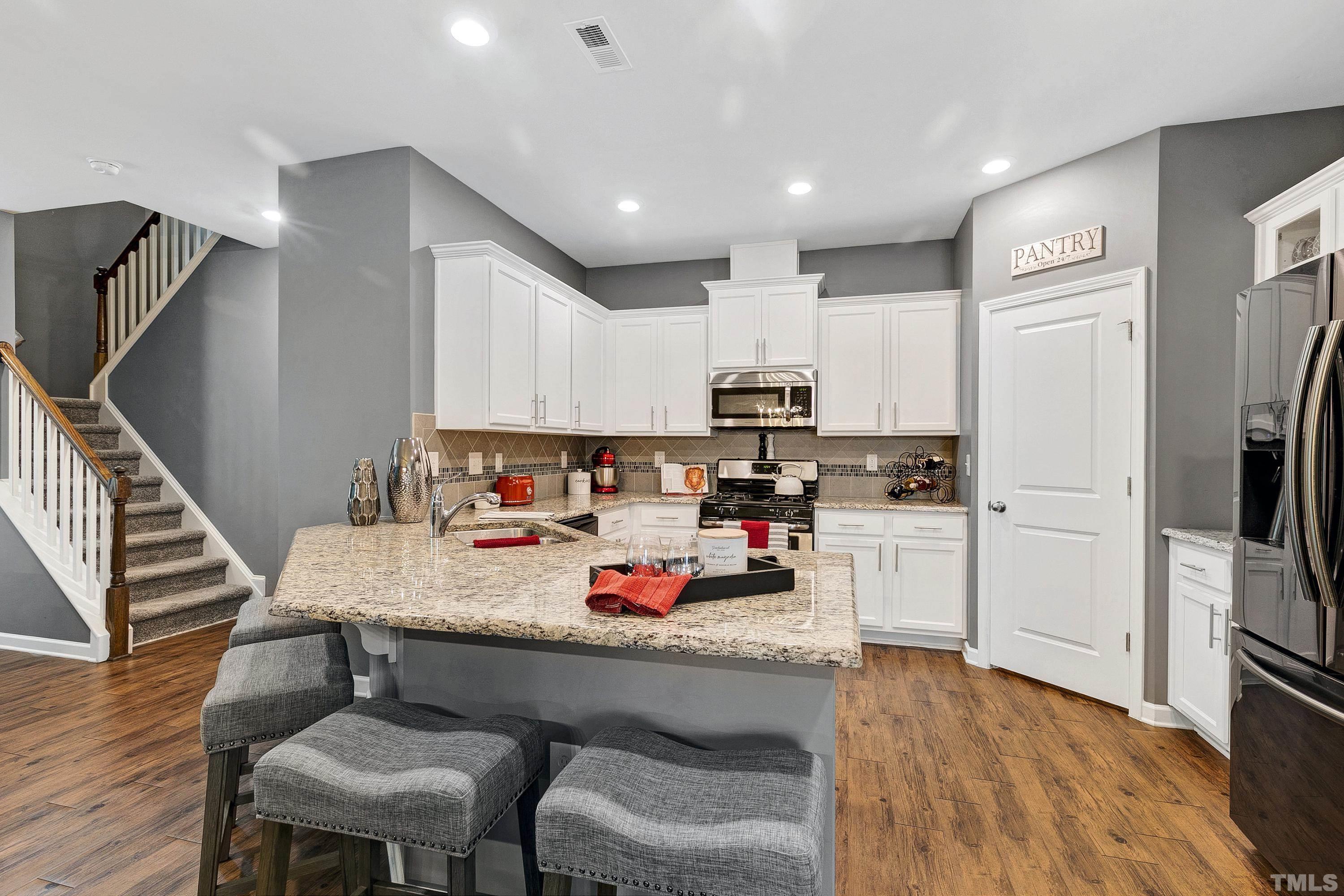 1161 Lookout Ridge Road Apex, NC 27502 - Photo 13 of 36 a kitchen with counter space dining table and stainless steel appliances