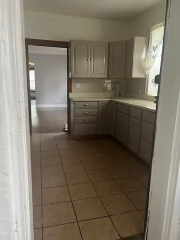 a kitchen with a sink a refrigerator and cabinets