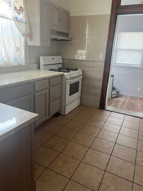 9735 South Michigan Avenue, Unit 1 Chicago, IL 60628 - Photo 5 of 17 a kitchen with a sink a stove and a refrigerator