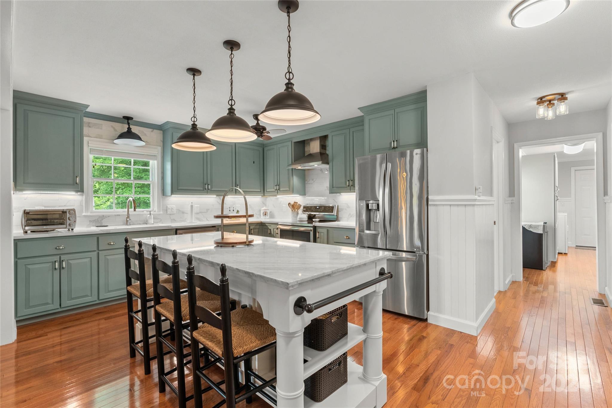1154 Landrum Road Columbus, NC 28722 - Photo 12 of 36 a kitchen with stainless steel appliances granite countertop a refrigerator a sink a stove and a dining table with wooden floor