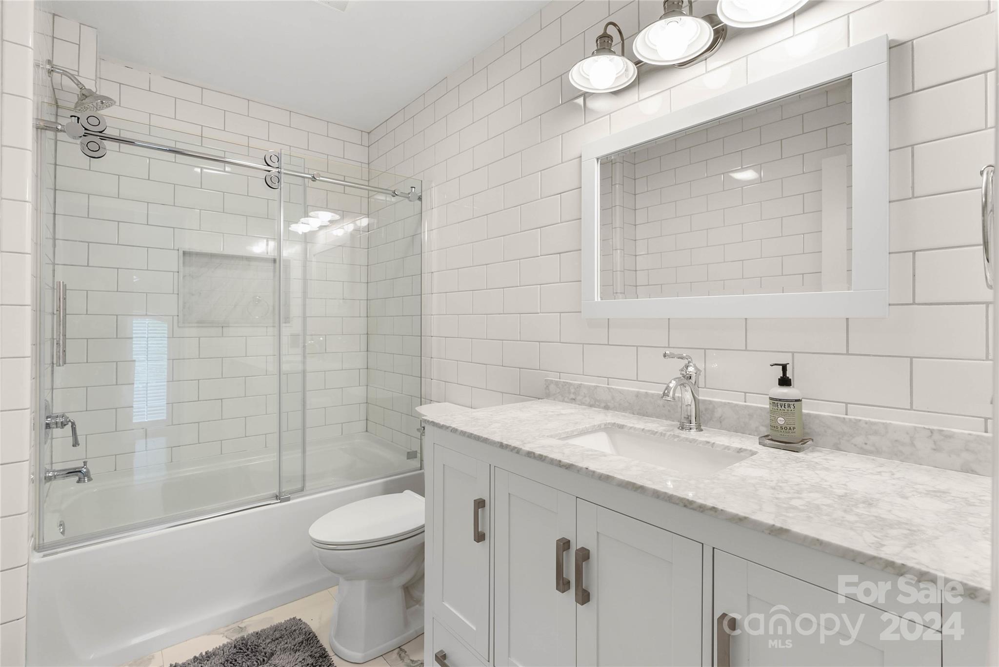 1154 Landrum Road Columbus, NC 28722 - Photo 21 of 36 a bathroom with a granite countertop sink toilet and shower
