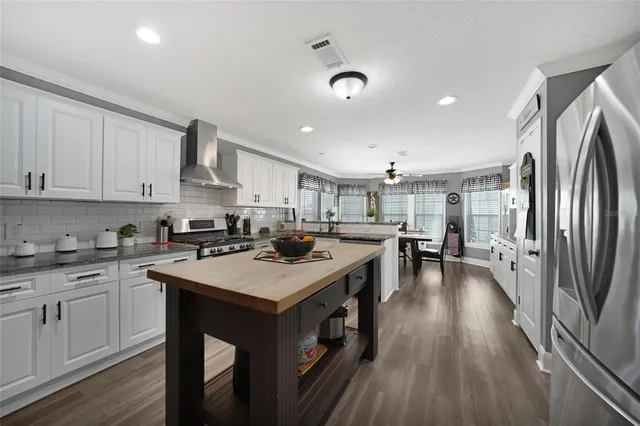 a kitchen with a sink a counter top space stainless steel appliances and cabinets