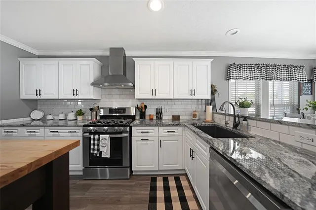 a kitchen with stainless steel appliances granite countertop a stove sink and cabinets