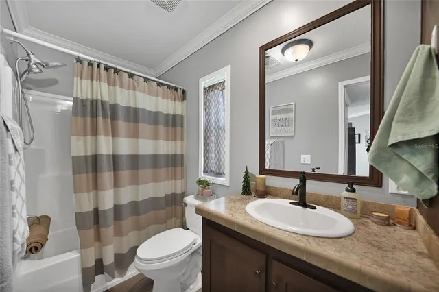 a bathroom with a sink a toilet a shower curtain and a mirror