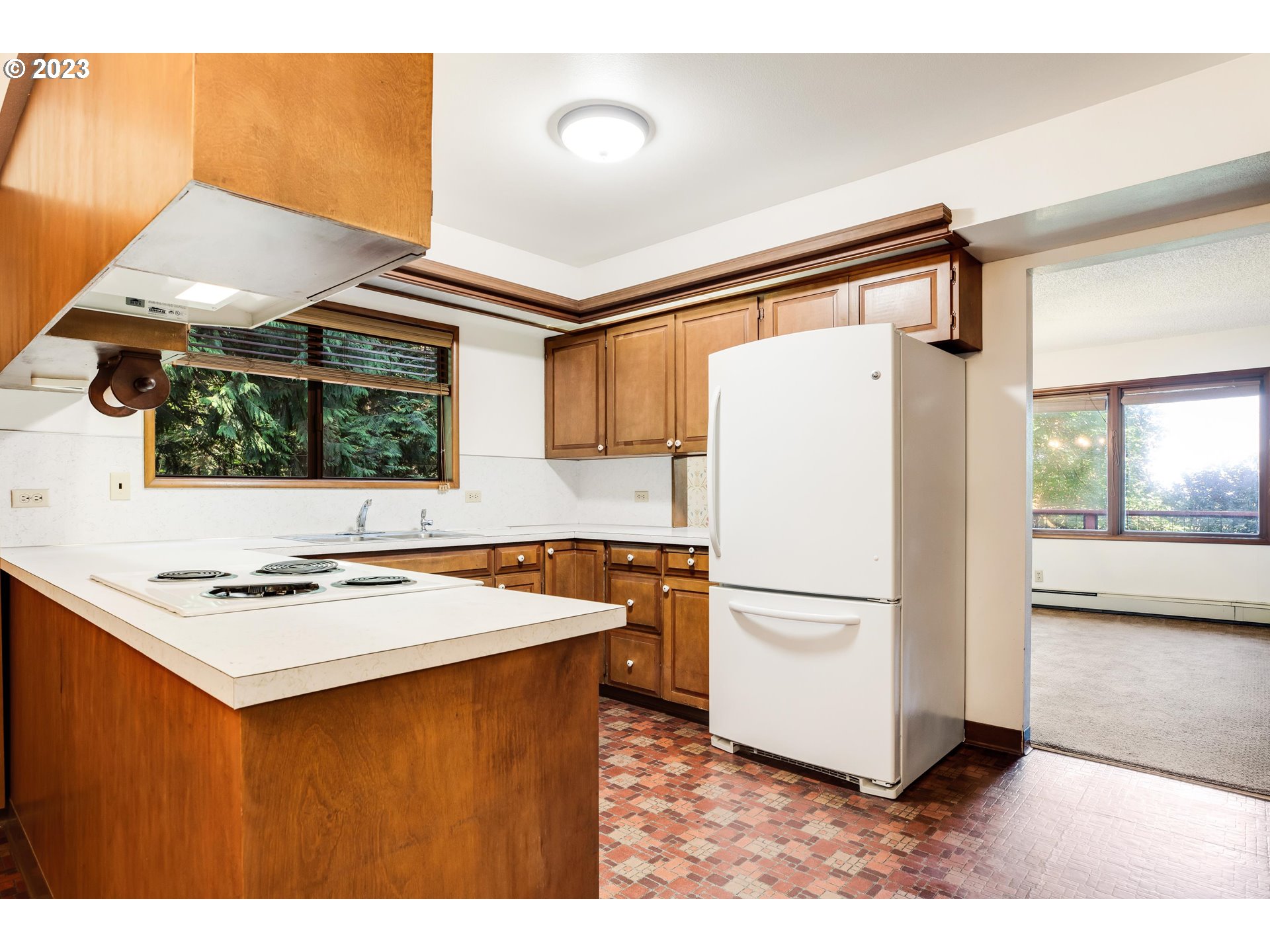 15729 Northwest Sheltered Nook Road Portland, OR 97231 - Photo 15 of 44 a kitchen with stainless steel appliances granite countertop a refrigerator a sink dishwasher a stove with white cabinets and wooden floor