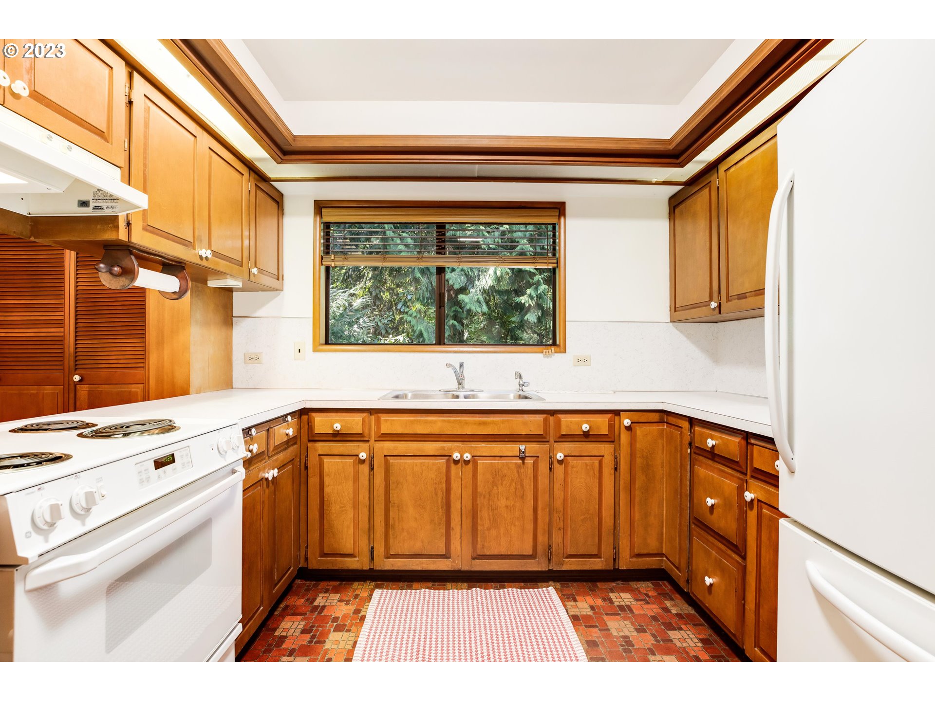 15729 Northwest Sheltered Nook Road Portland, OR 97231 - Photo 16 of 44 a view of a kitchen with a sink and dishwasher next to a window