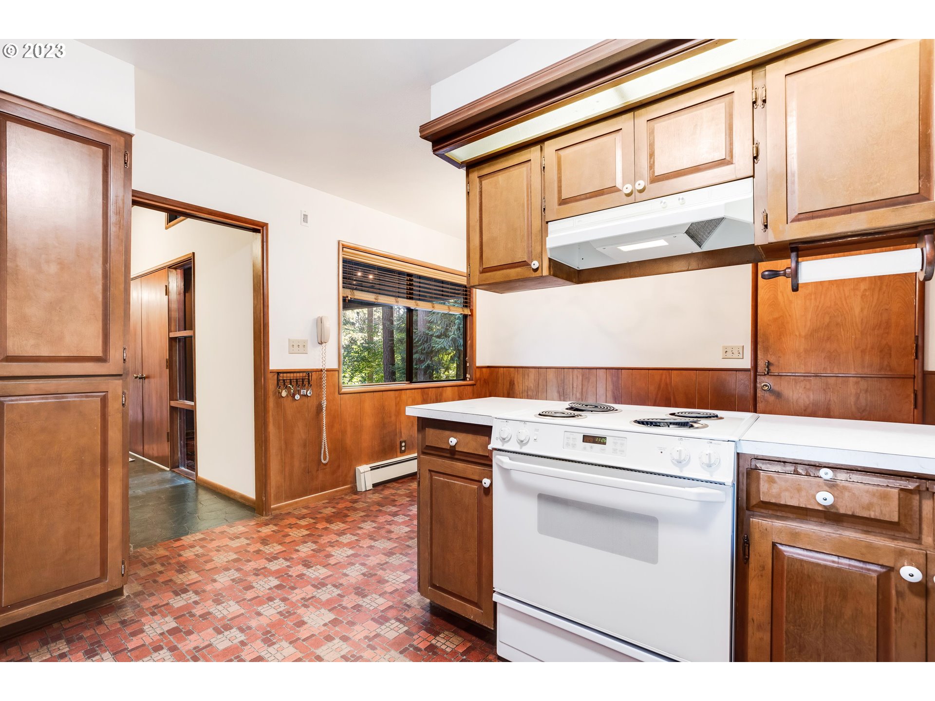 15729 Northwest Sheltered Nook Road Portland, OR 97231 - Photo 17 of 44 a kitchen with a stove top oven cabinets and a refrigerator