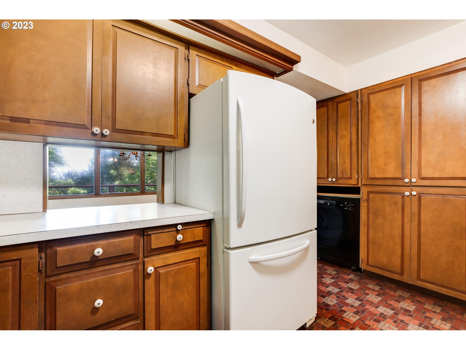 15729 Northwest Sheltered Nook Road Portland, OR 97231 - Photo 18 of 44 a kitchen with a refrigerator and cabinets